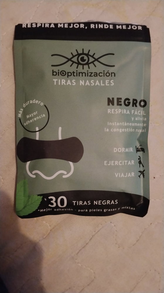 Pack de tiras nasales negras con esencia de menta apoyado sobre piso claro