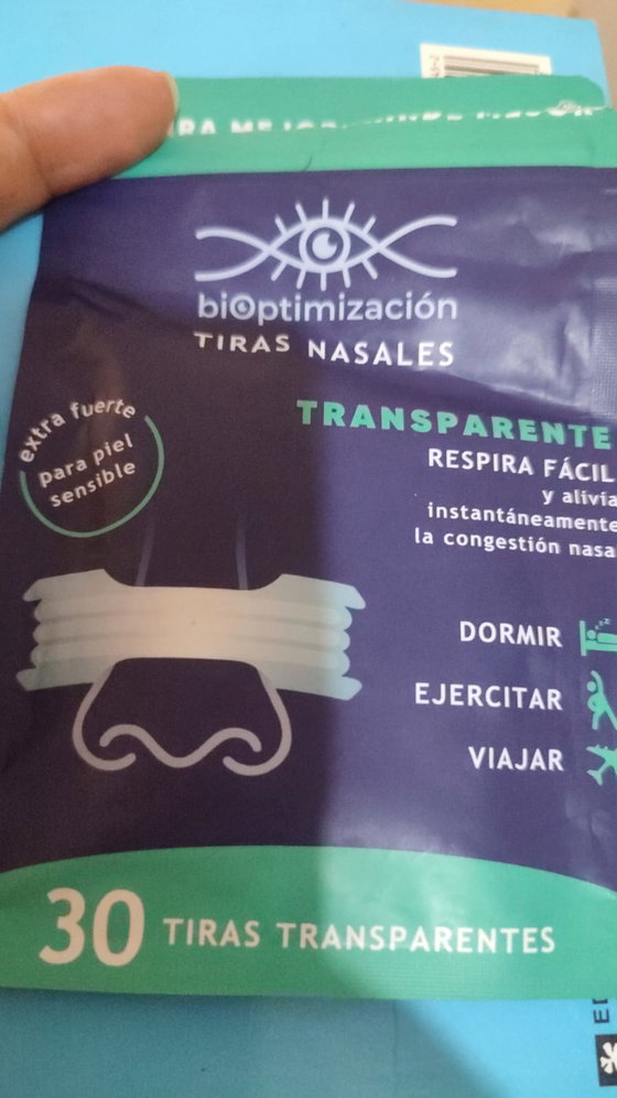 Mano sosteniendo el pack de tiras nasales transparentes con luz natural