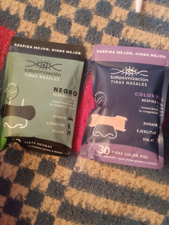 Packs de tiras nasales negras y color piel juntos sobre una alfombra