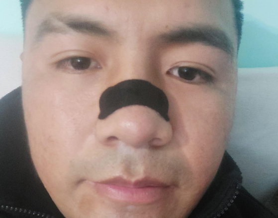 Selfie de cliente en interior con la tira nasal negra aplicada sobre la nariz