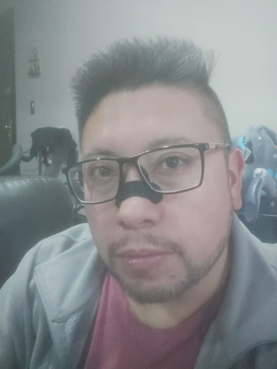 Cliente con lentes en casa mostrando la tira nasal negra puesta