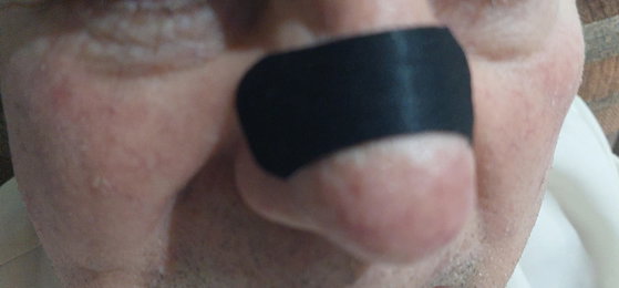 Primer plano de una nariz con la tira nasal negra aplicada