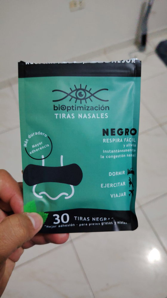 Mano sosteniendo el pack de tiras nasales negras en interior