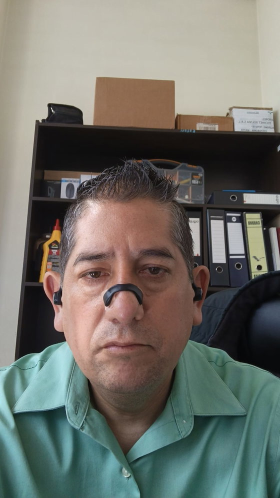Cliente en su oficina con el dilatador nasal magnético negro puesto sobre la nariz
