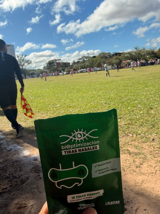 Mano sosteniendo el pack verde de tiras nasales Edición Tierra al aire libre
