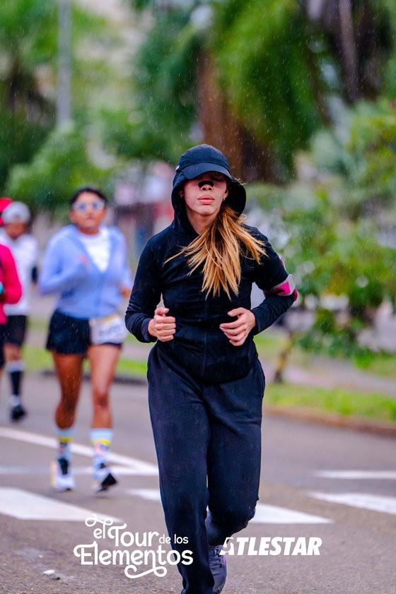 Corredora con la tira nasal negra puesta durante una carrera bajo la lluvia