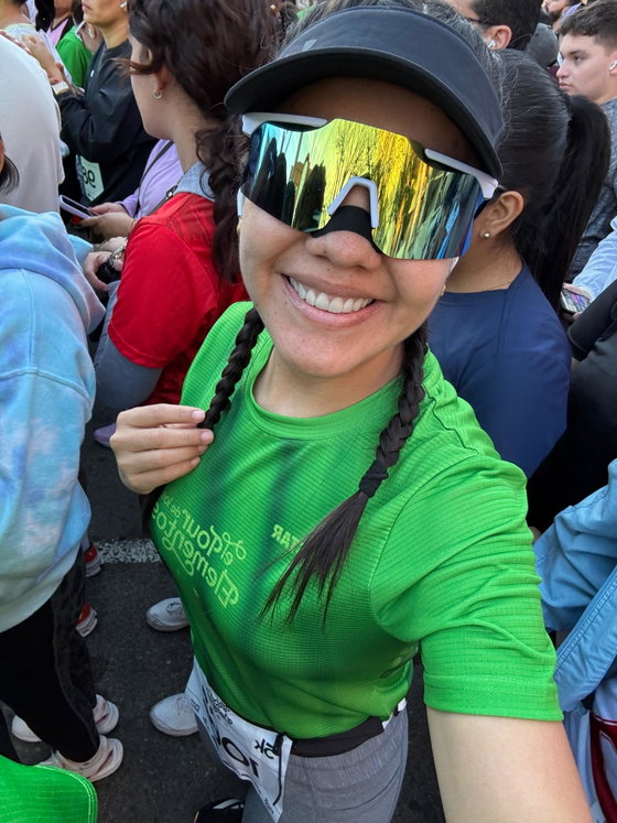 Corredora con gorra y lentes deportivos en la largada de una carrera, con la tira nasal negra puesta